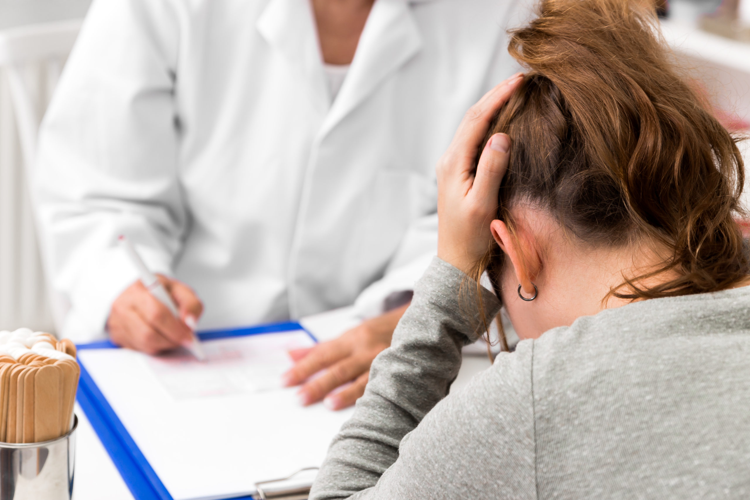 Woman in distress, receiving information from a doctor.